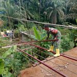 Bahu Membahu Demi Kemajuan Desa, Babinsa dan Warga Pasang Tali Seling Jembatan Gantung Bosar Galugur.