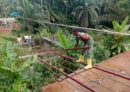 Bahu Membahu Demi Kemajuan Desa, Babinsa dan Warga Pasang Tali Seling Jembatan Gantung Bosar Galugur.
